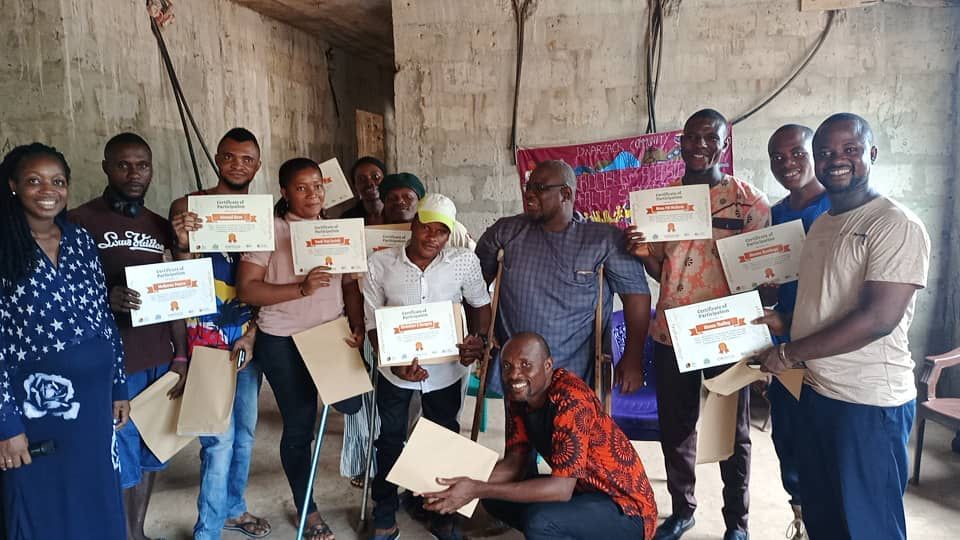 Participants in the AT2003 project hold up their certificates of participation on International Day of Persons with Disabilities